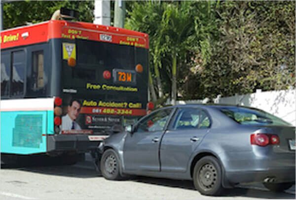 Car accident where the car crashes into the back of a bus