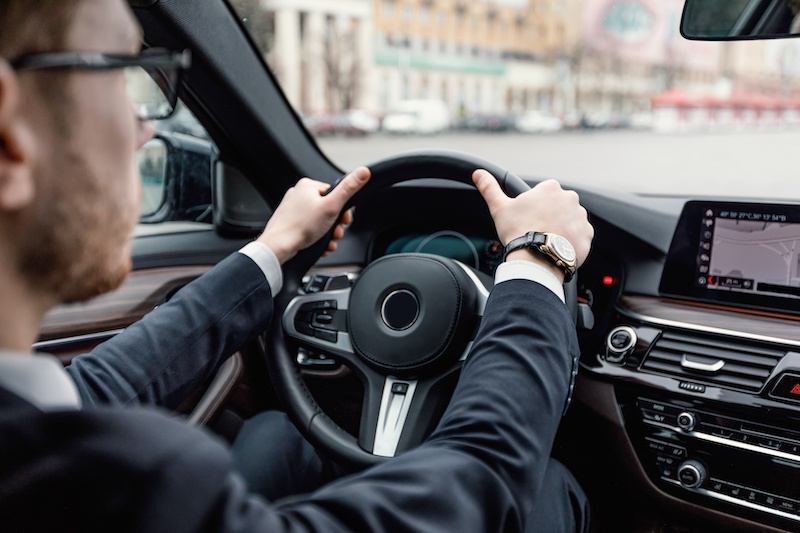 Rear view of man in glasses driving back home