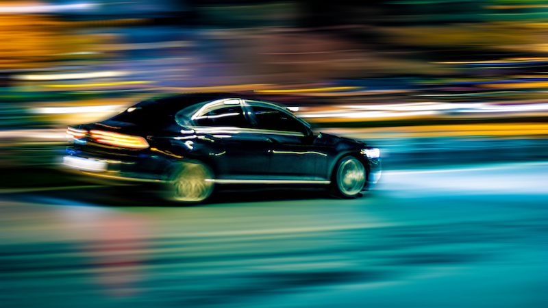 Black car speeding on the road